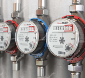 Row of water meters of cold and hot water on the wall background. 3d illustration